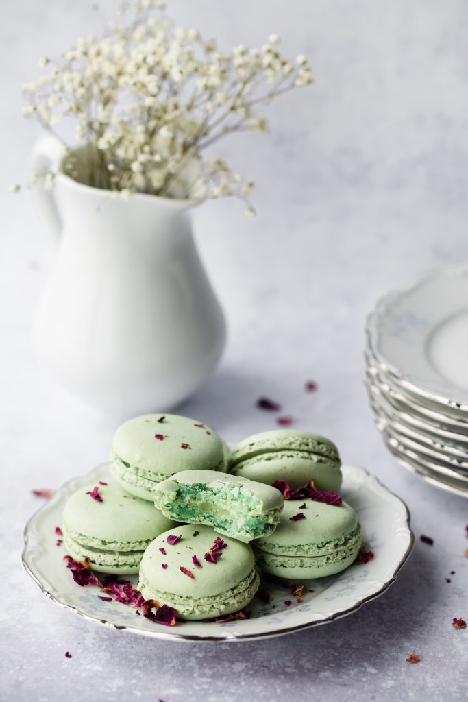 In questa foto un piccolo piatto con macarons di colore verde posizionato su un tavolo per un menù di nozze francese