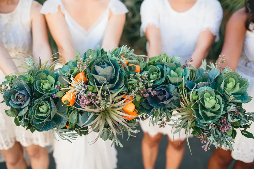 In questa foto le mani di una sposa e delle sue tre damigelle che tengono i loro bouquet di verdura e fiori
