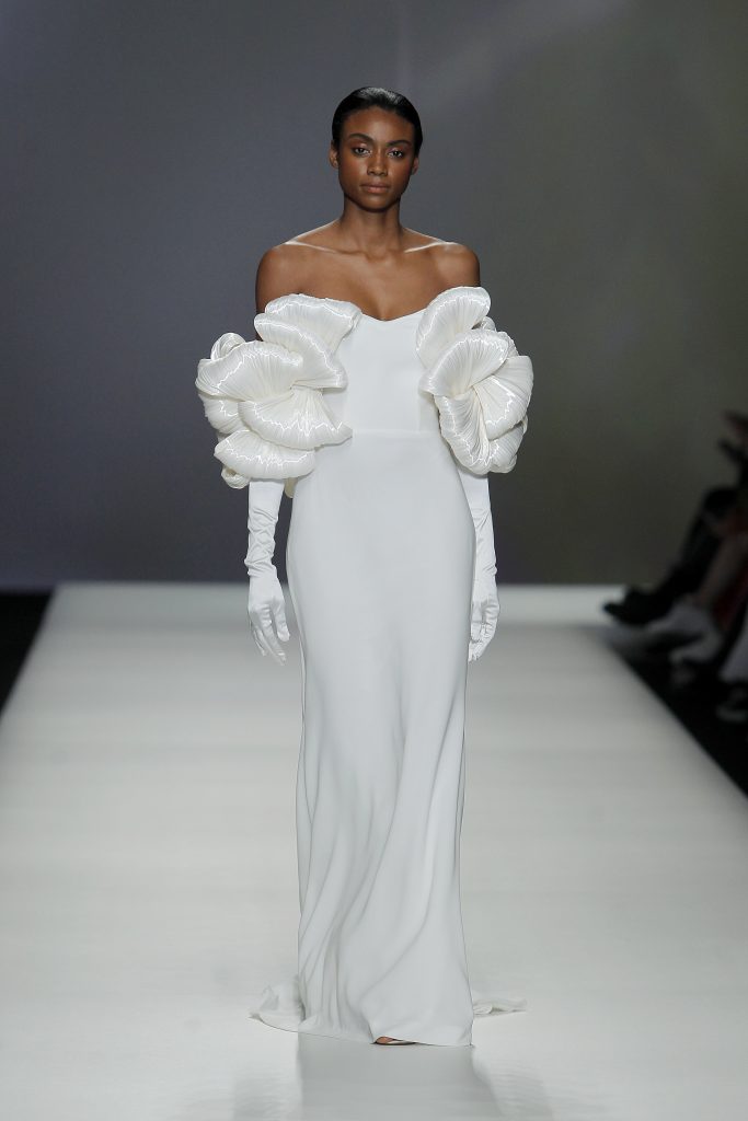 In questa foto la modella indossa un abito da sposa con maniche voluminose e guanti.