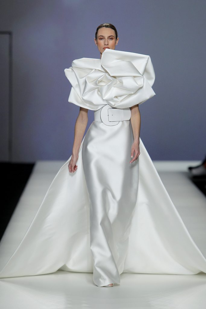 In questa foto la modella indossa un abito da sposa Isabel Sanchis 2023 con gonna svasata e volume sulla parte superiore.
