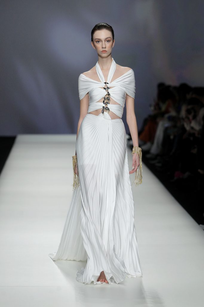 In questa foto la modella indossa un abito da sposa con tagli simmetriici e catena centrale.