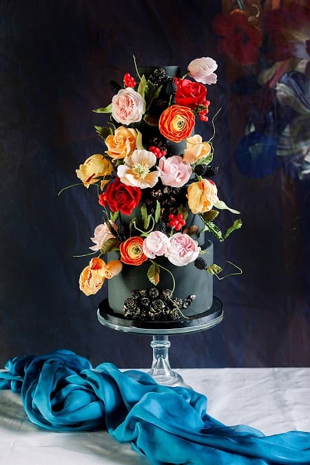 In questa foto, grandi fiori matrimonio stile barocco dai colori accesi decorano una torta nuziale