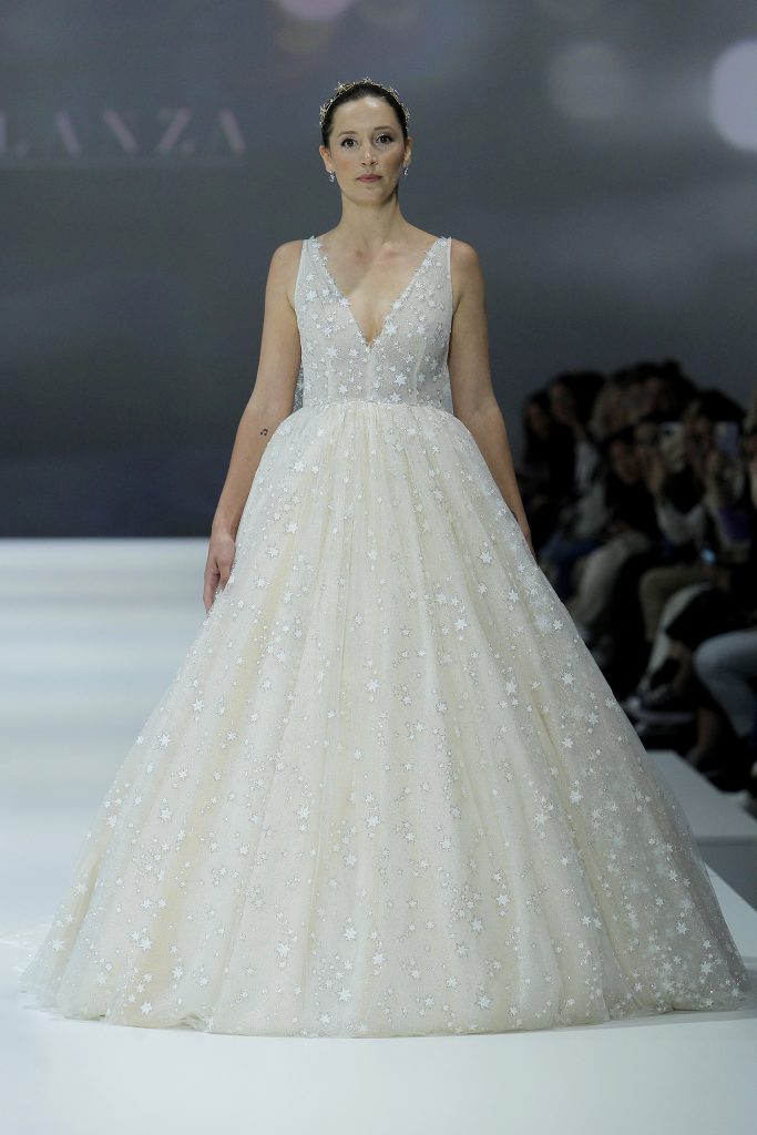 In questa foto la modella indossa un abito da sposa di tulle colorato con stelle di Andrea Lalanza 2023.