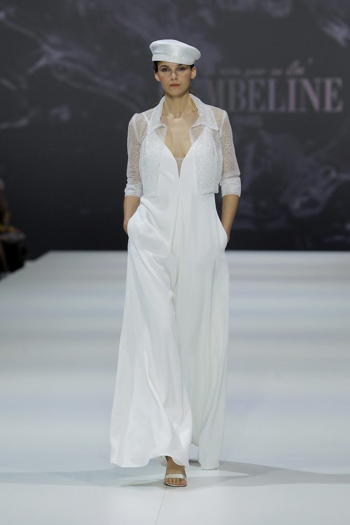 In questa foto la modella indossa una tuta jumpsuit bianca da sposa Cymbeline 2023.