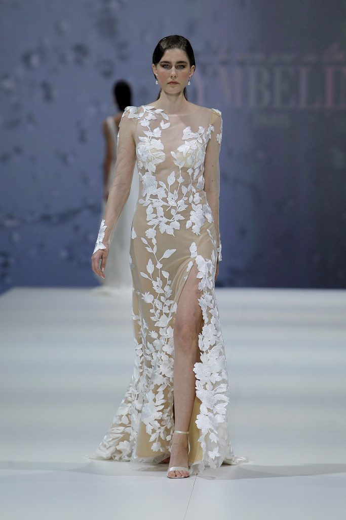 In questa foto la modella indossa un abito da sposa nude con ricami floreali bianchi.