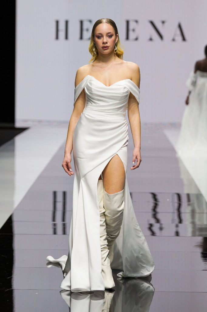 In questa foto la modella indossa un abito da sposa con spalline scivolate e profondo spacco frontale.