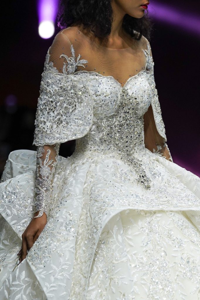 In questa foto la modella indossa un abito da sposa ampio con ruches e cristalli.