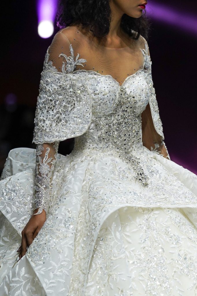 In questa foto la modella indossa un abito da sposa ampio con ruches e cristalli.