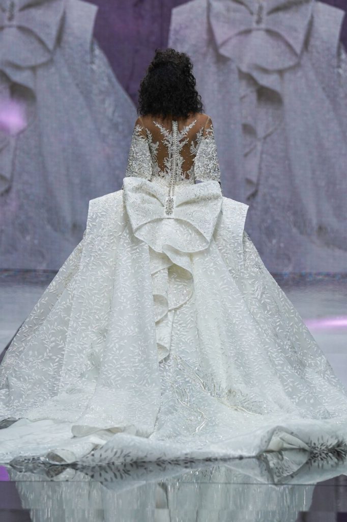 In questa foto la modella indossa un abito da sposa ampio con rmaxi fiocco sul retro.