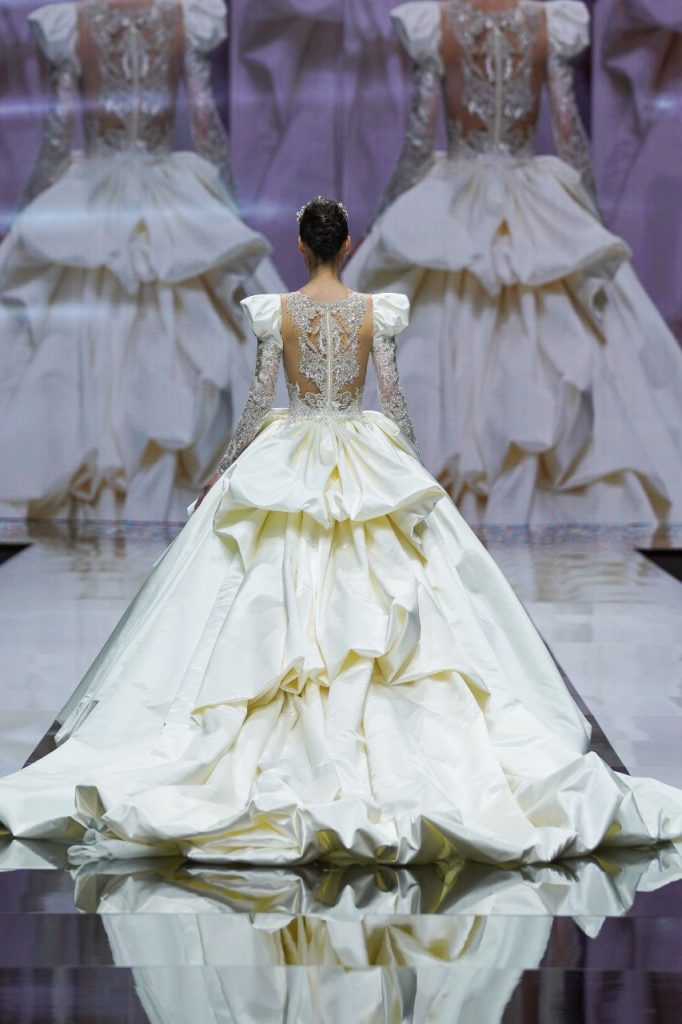 In questa foto la modella indossa un abito da sposa ampio con ruches sul retro.