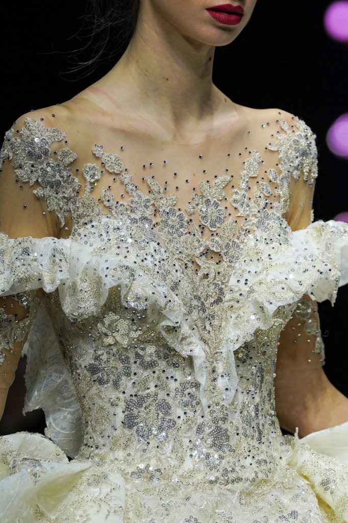 In questa foto la modella indossa un abito da sposa con decori floreali ricchi di paillettes.