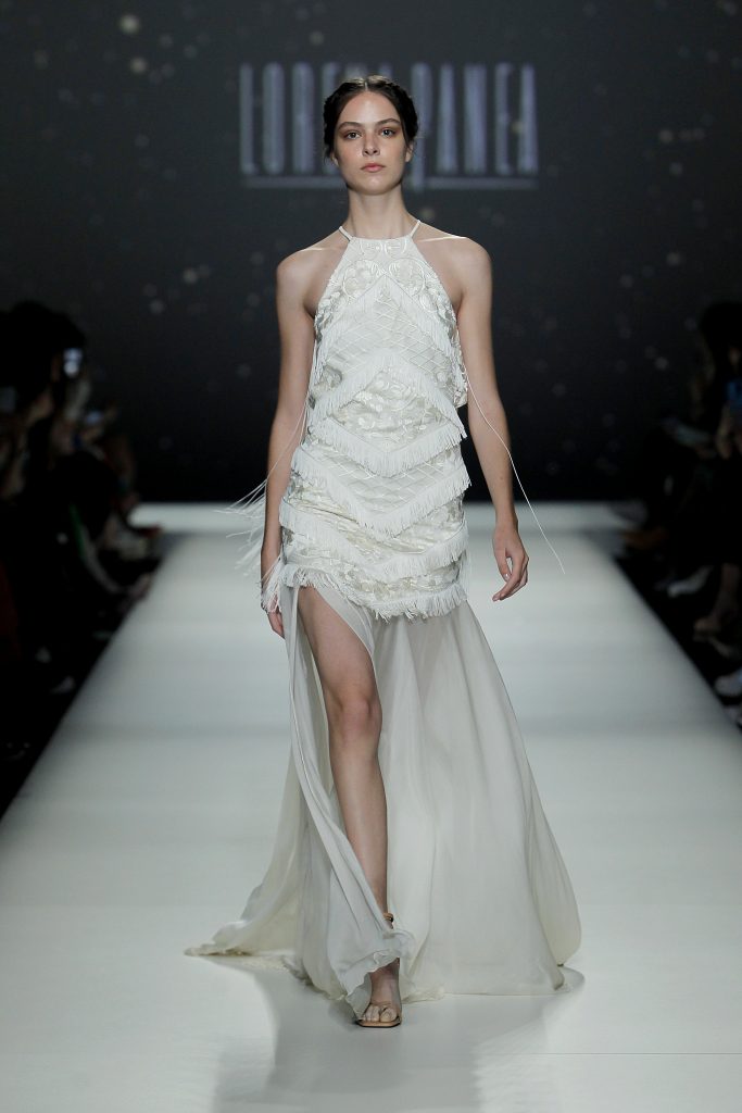 In questa foto la modella indossa un abito da sposa con frange e damascato di Lorena Panea 2023.