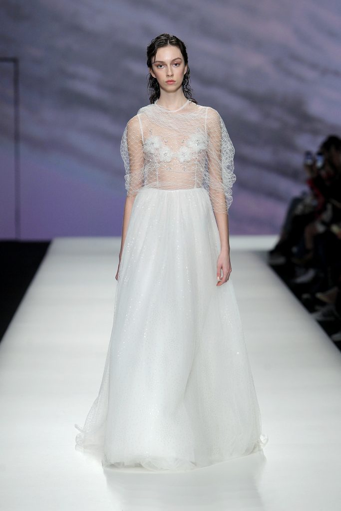 In questa foto la modella indossa un abito da sposa con retina trasparente.