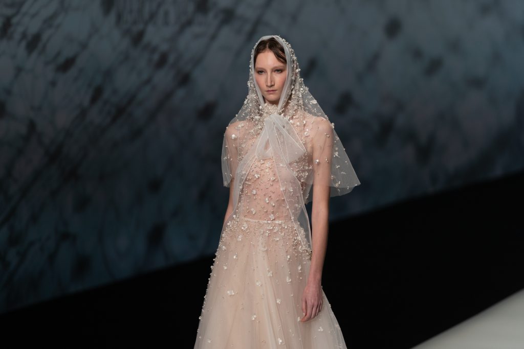 In questa foto la modella indossa un abito da sposa di tulle con perle.