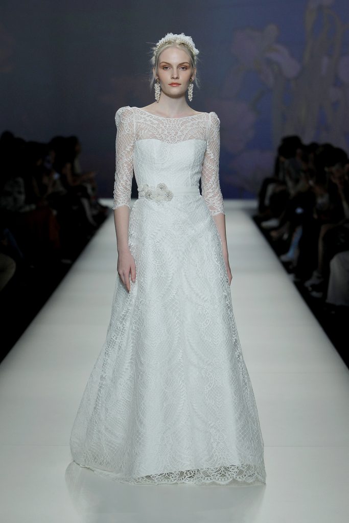 In questa foto una modella indossa un abito da sposa con trasparenze e pattern ricamato.