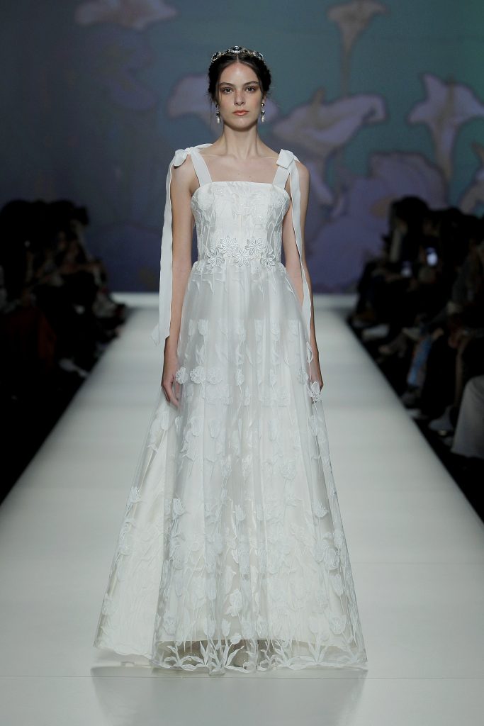 In questa foto una modella indossa un abito da sposa con ricami floreali della collezione More 2023.