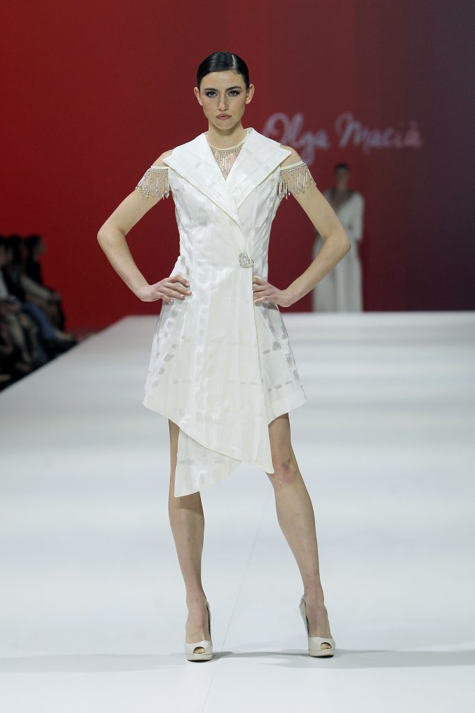 In questa foto la modella indossa un abito da sposa a giacca senza maniche di Olga Macià.