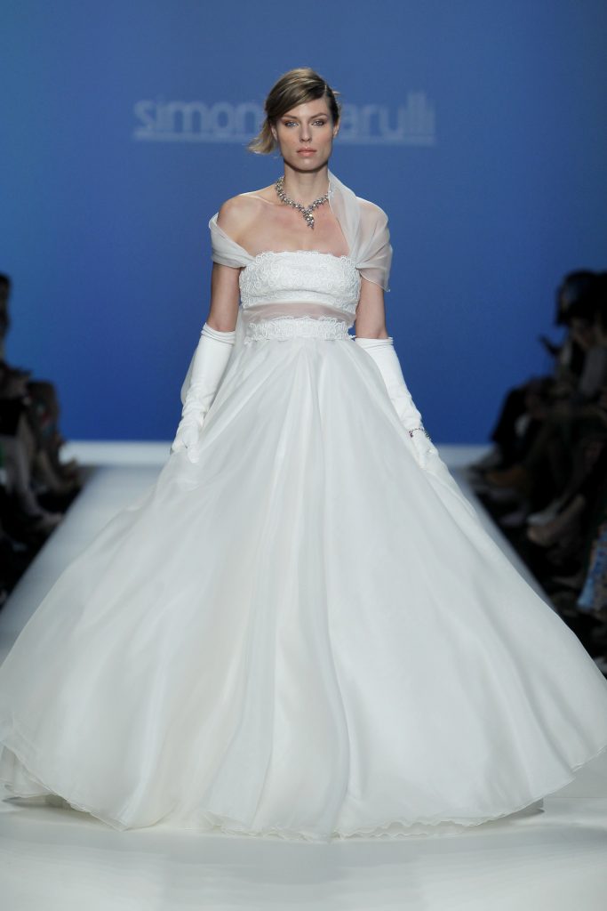 In questa foto al modella indossa un abito da sposa ampio con manica di velo.