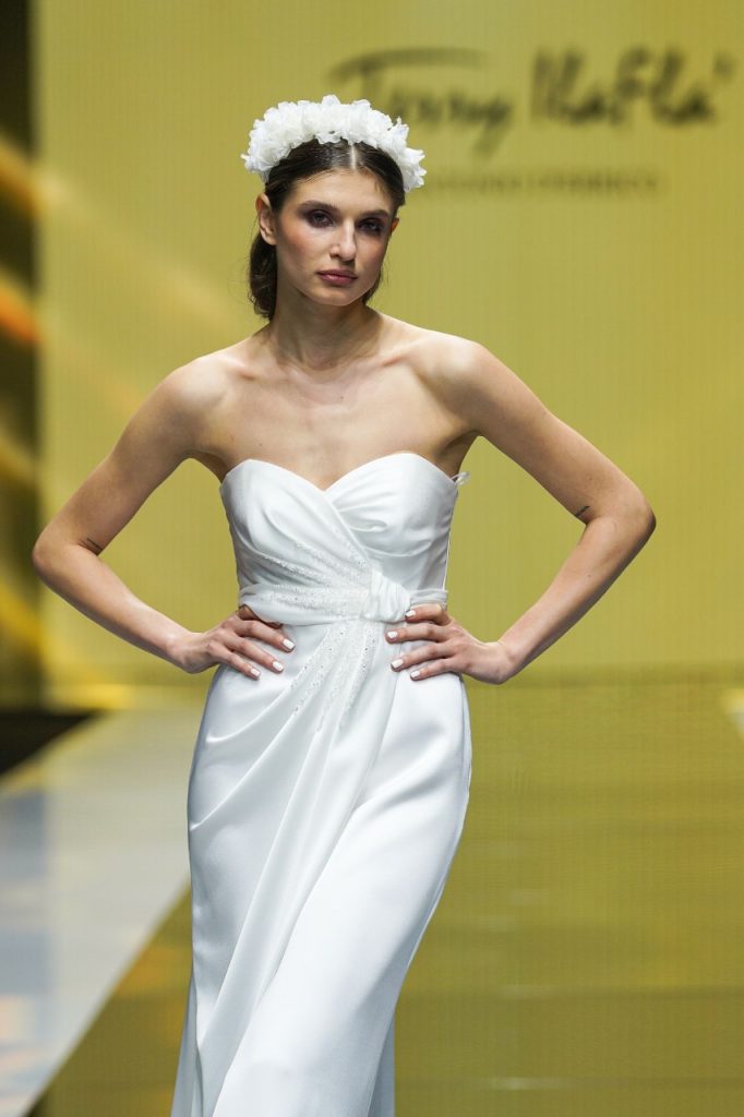 In questa foto la modella indossa un abito da sposa con micro drappeggi senza maniche.