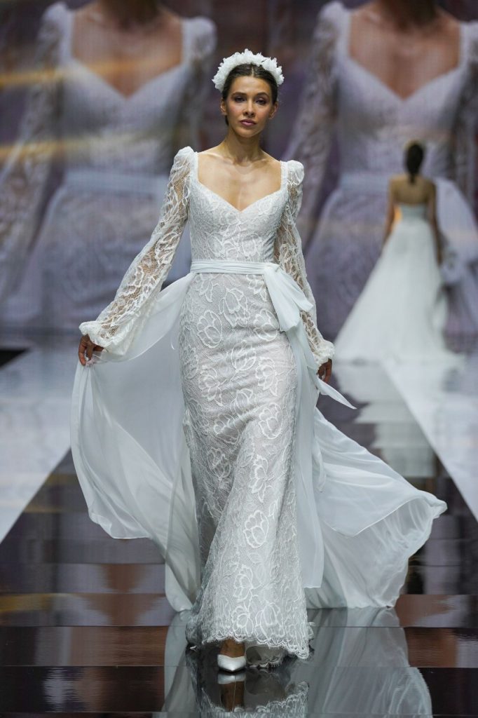 In questa foto la modella indossa un abito da sposa Terry Ilaflà 2023 con maniche lunghe di pizzo floreale.