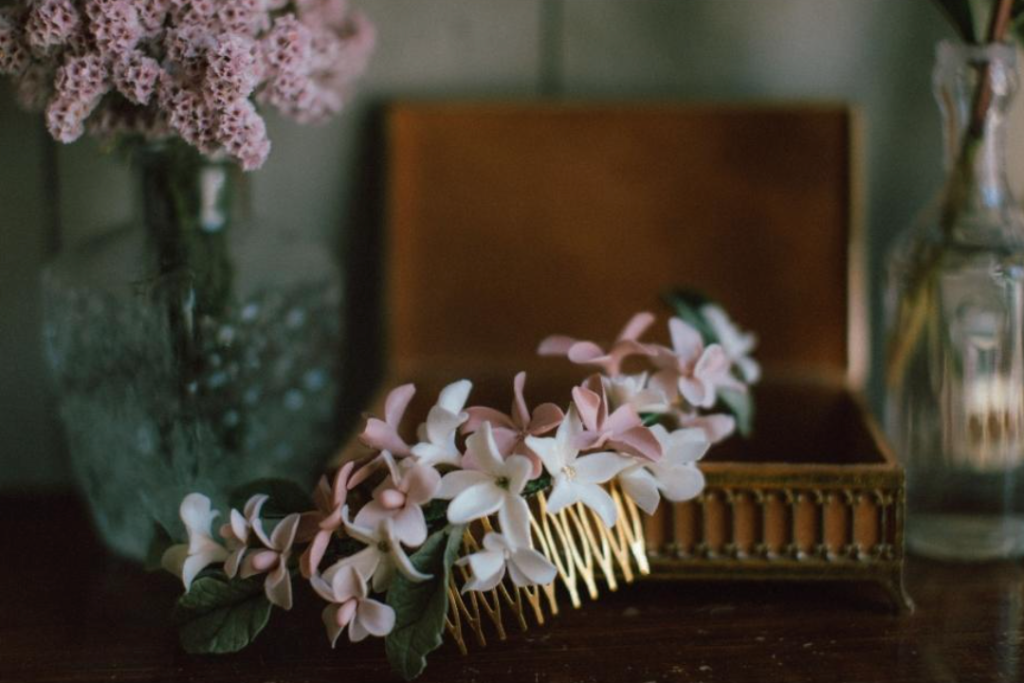 In questa foto un fermaglio per capelli da sposa di Cristina Signorina con fiori 3D di colore rosa e bianco