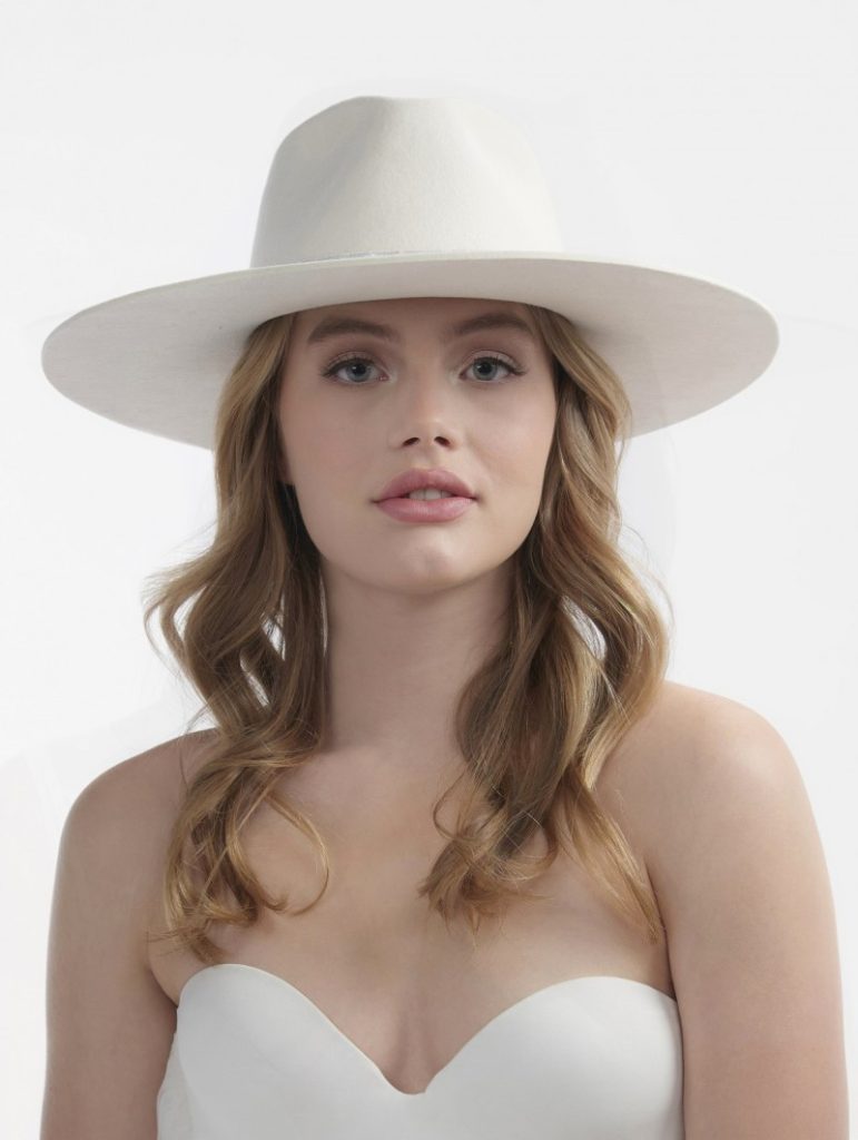 In questa foto una modella indossa un cappello da sposa a falda larga