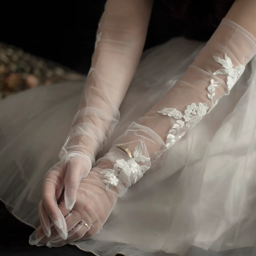 In questa foto guanti da sposa in tulle con inserti di pizzo sulle lunghezze
