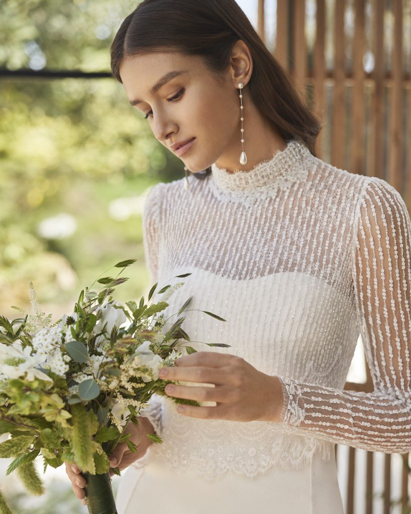 In questa foto un elegante coprispalla Rosa Clarà decorato con perline a forma di fiore.