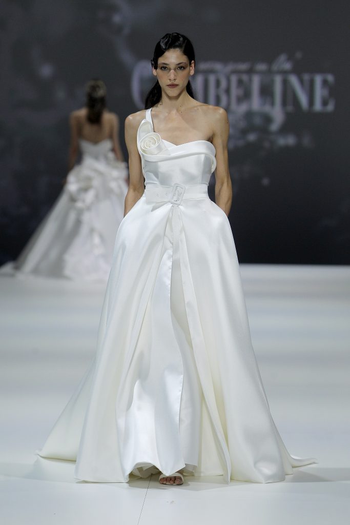 In questa foto la modella indossa un abito da sposa monospalla con dettaglio 3D.