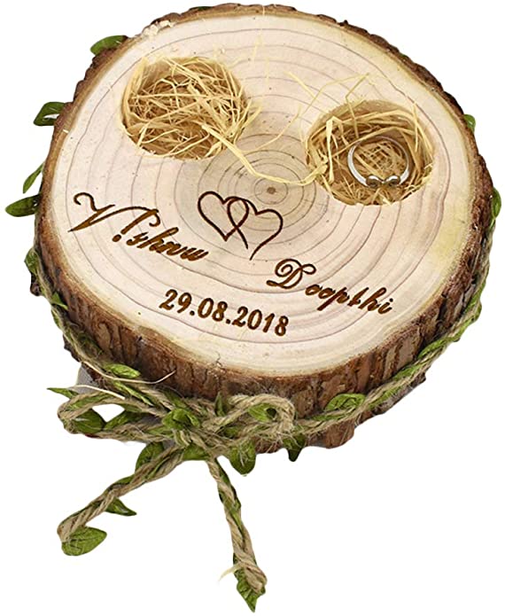 In questa foto un portafedi creato con un tronco di legno con incisi i nomi degli sposi e la data delle nozze