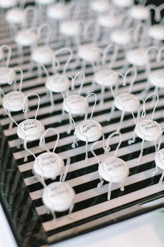 In questa foto sigilli di alluminio per bottiglie colore bianco usati come segnaposto di nozze 