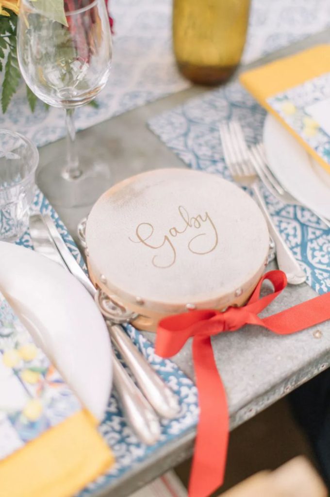 In questa foto un tamburello con il nome di un ospite usato come segnaposto di un matrimonio in stile siciliano