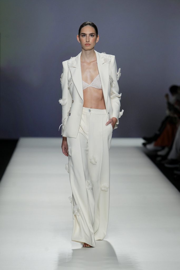 In questa foto la modella indossa un abito da sposa con giacca e pantaloni Isabel Sanchis 2023.