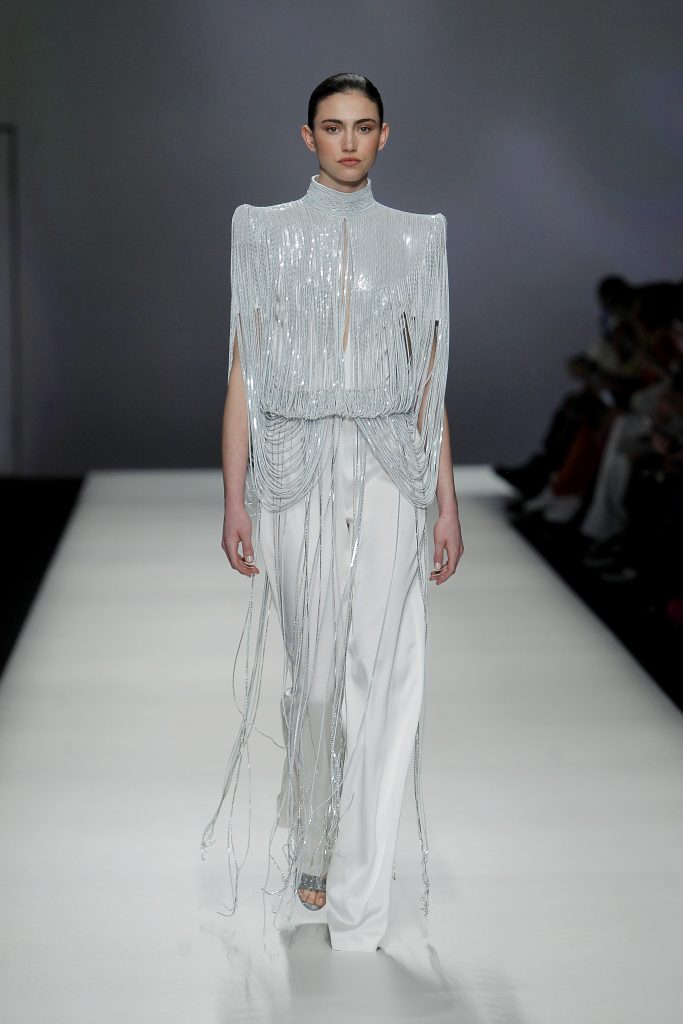 In questa foto la modella indossa un abito da sposa con pantaloni 2023 con frange argento.