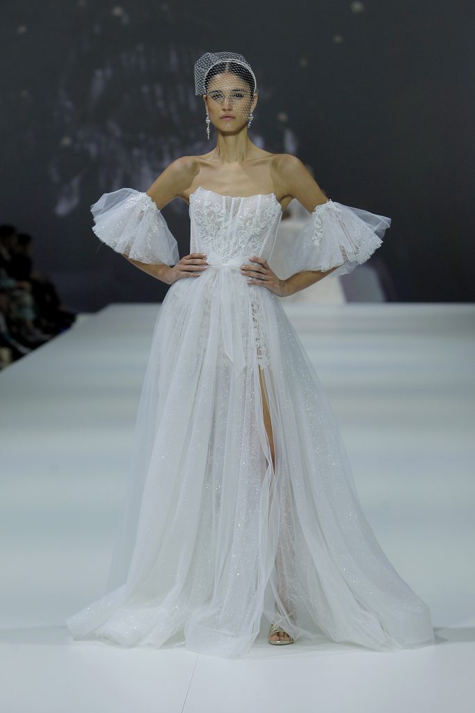 In questa foto la modella indossa un abito da sposa con spacco 2023 di tulle.