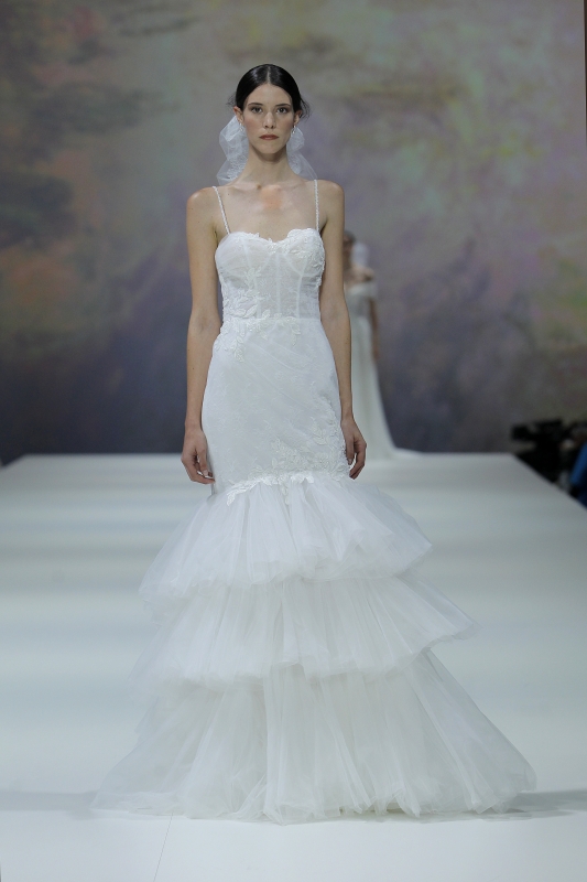 In questa foto la modella indossa un abito da sposa a sirena con balze finali 2023.