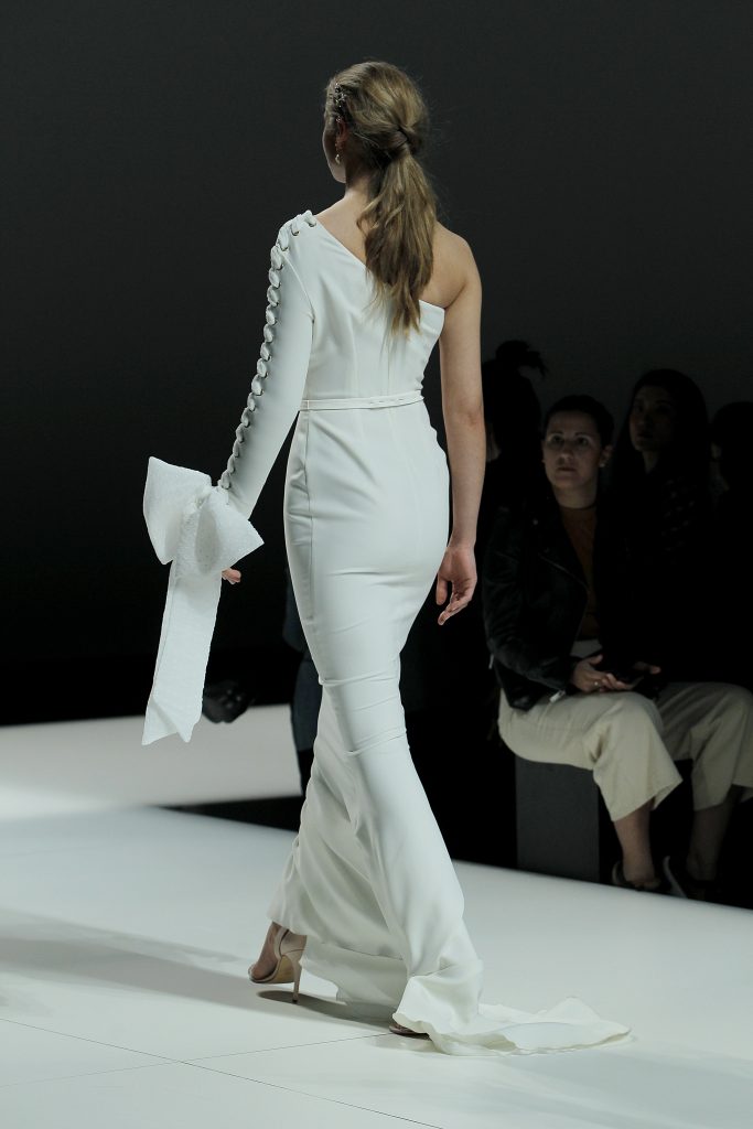 In questa immagine la modella indossa un abito da sposa con fiocco sulla manica Nicolas Montenegro 2023.