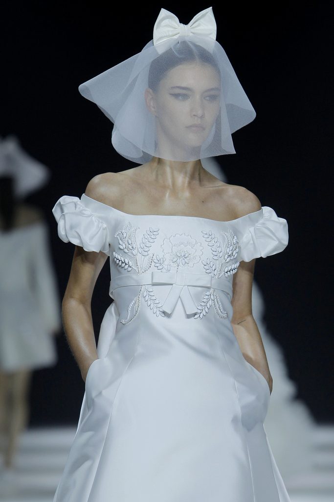 In questa foto la modella indossa un abito da sposa corto con fiocco e maniche a sbuffo Viktor Rolf 2023.