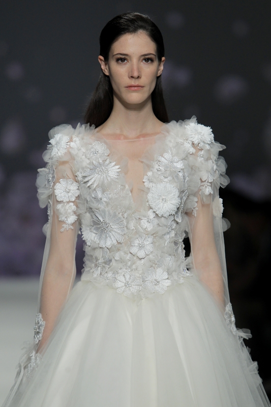 In questa foto la modella indossa un abito da sposa con fiori 3D e scollo a V, con gonna di tulle.