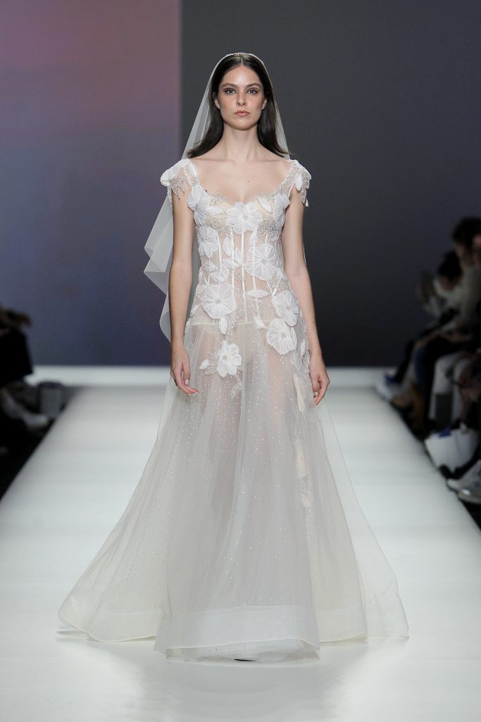 In questa foto la modella indossa un abito da sposa di tulle con fiori 3D.