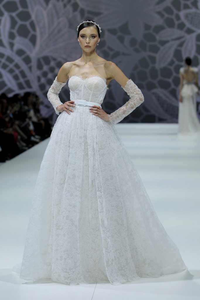 In questa foto la modella indossa un abito da sposa con maniche removibili Nicole Milano 2023.