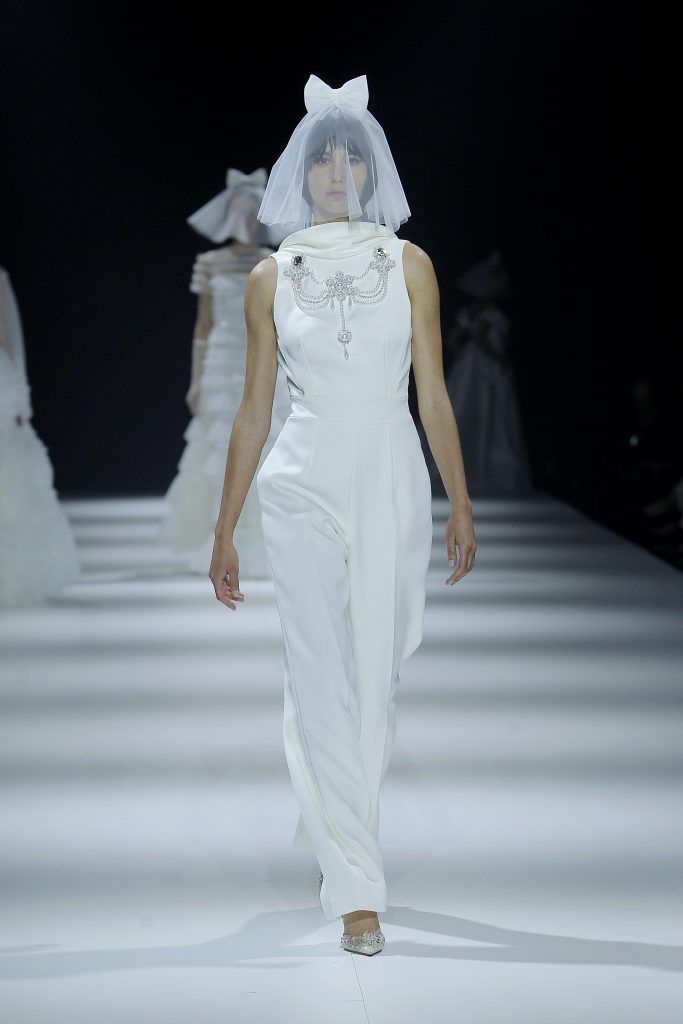 In questa foto la modella indossa un abito da sposa jumpsuit 2023 con collana gioiello.