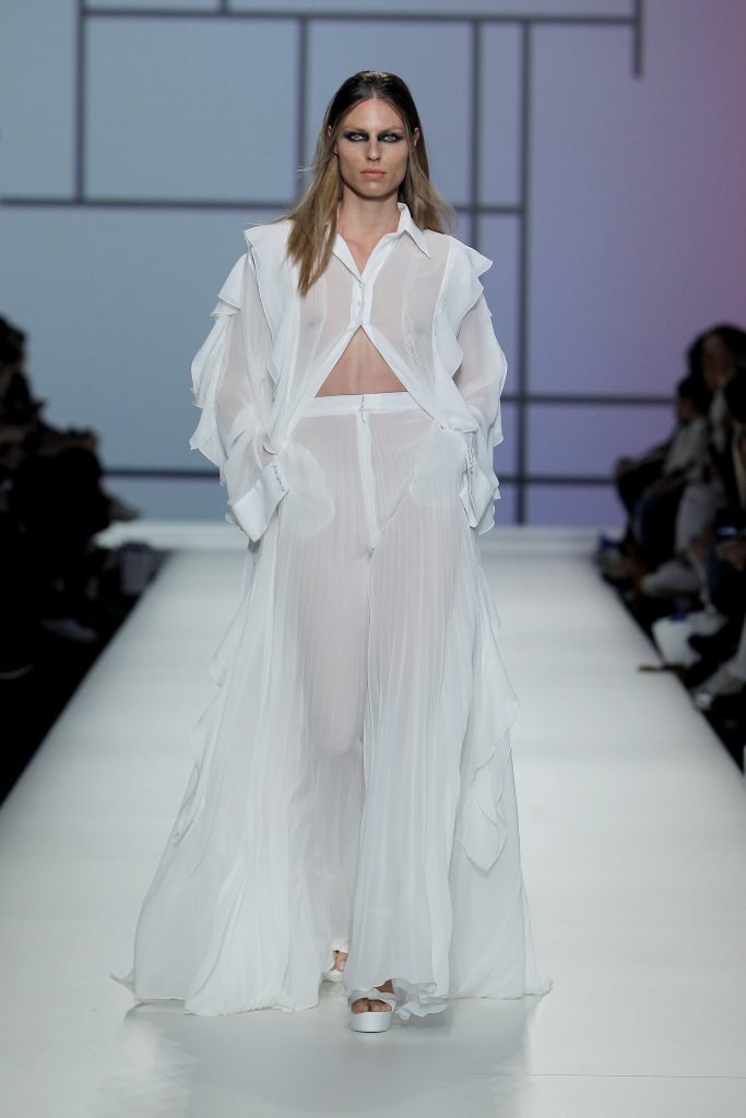 In questa foto la modella indossa un abito da sposa con pantaloni e camicia trasparente Yolancris.