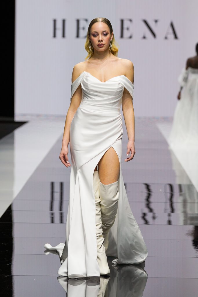 In questa foto la modella indossa un abito da sposa a sirena con spacco laterale Helena 2023.