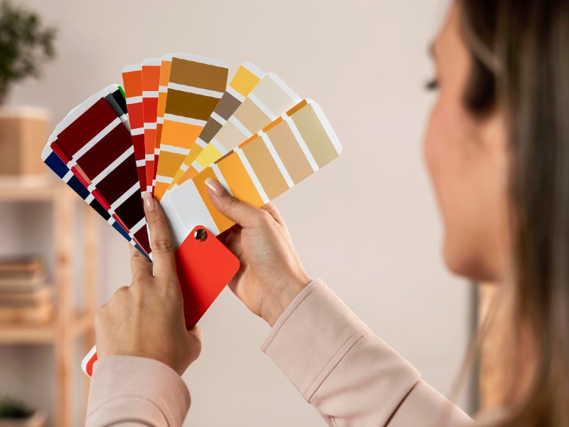 In questa foto un esperta di armocromia sposa ripresa di spalle studia le palette di colori