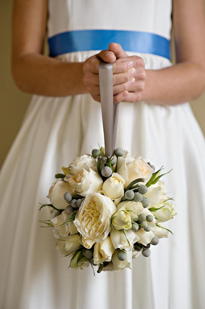 In questa foto un bouquet a borsetta per damigella con peonie e rose bianche e bacche grigie