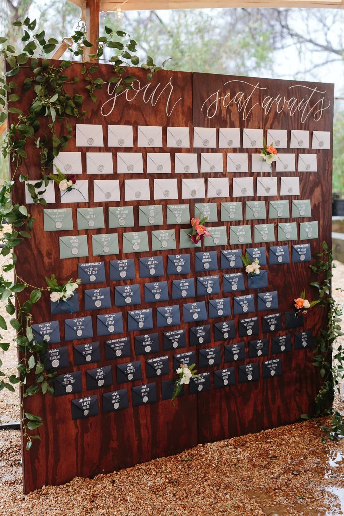 In questa foto escort card a forma di busta da lettera nei toni del bianco, del verde, del bianco, del blu e del turchese