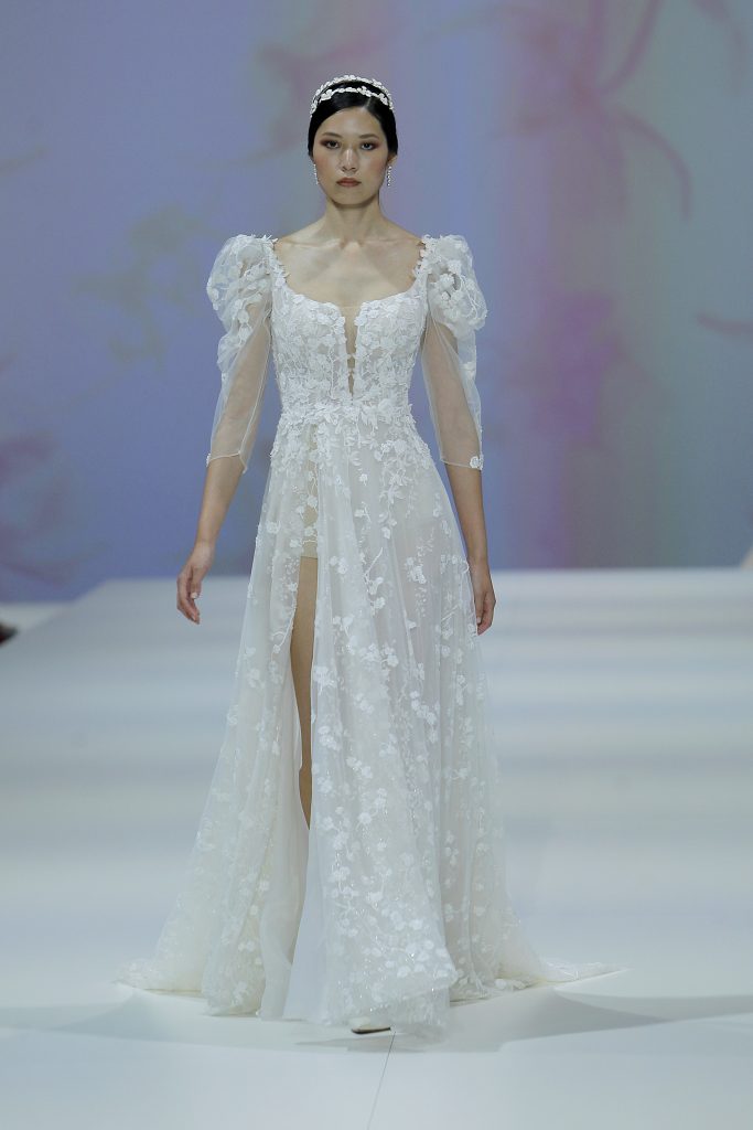 In questa foto al modella indossa un abito da sposa con spacco 2023 di tulle con fiori in rilievo.