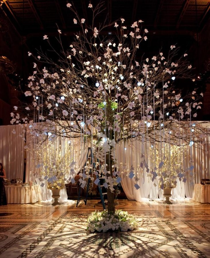 In questa foto un tableau mariage a tema albero della vita con cartoncini appesi ad un albero posto al centro della sala