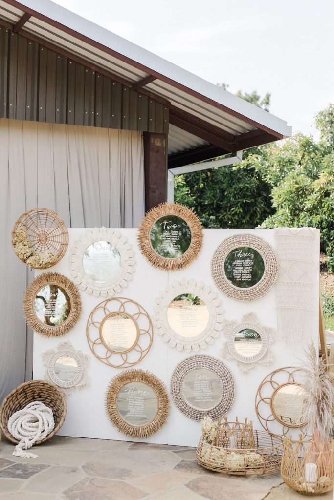 In questa foto un tableau matrimonio in stile Boho Chi con specchi di vimini e paglia